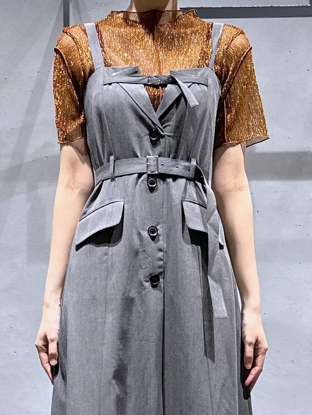 シルバー系のサンダル、オレンジ系のTシャツ/カットソー、グレー系のジャンパースカートを着用したレディースの夏コーディネートの7枚目の写真