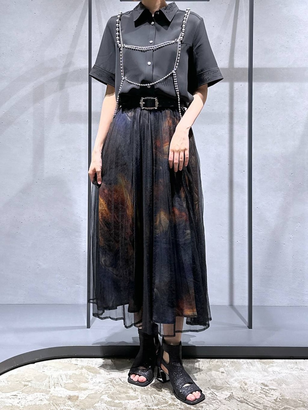 ブラック系のシャツ/ブラウス、ブラック系のサンダル、オレンジ系のスカートを着用したレディースの夏コーディネートの4枚目の写真