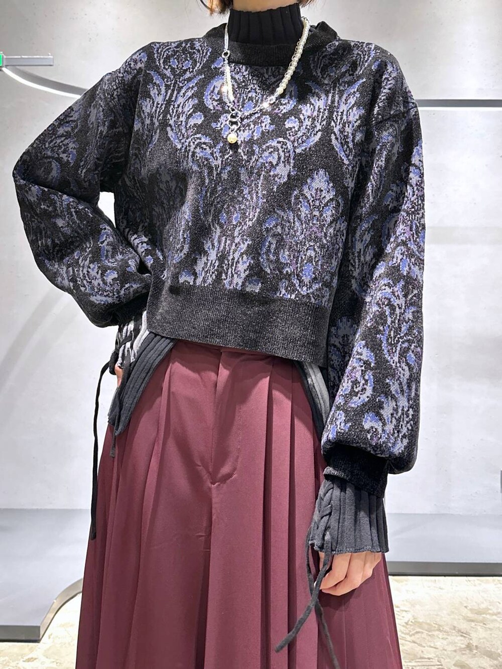 ブラック系のニット/セーター、ブラック系のローファー、レッド系のその他パンツを着用したレディースの秋コーディネートの5枚目の写真