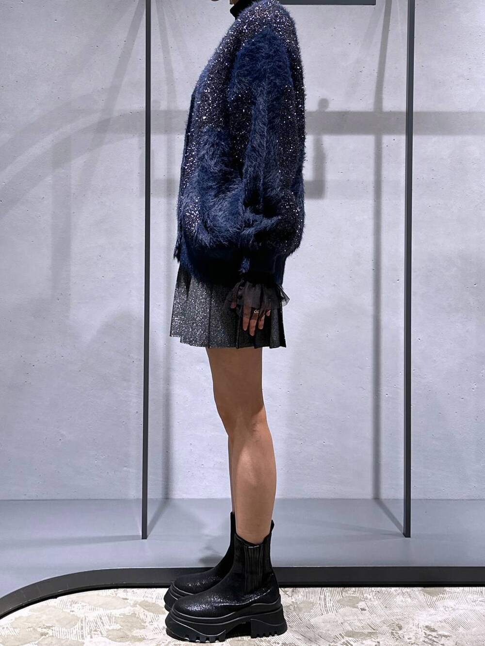 ブラック系のTシャツ/カットソー、ブラック系のブーツ、ブラック系のスカートを着用したレディースの冬コーディネートの2枚目の写真