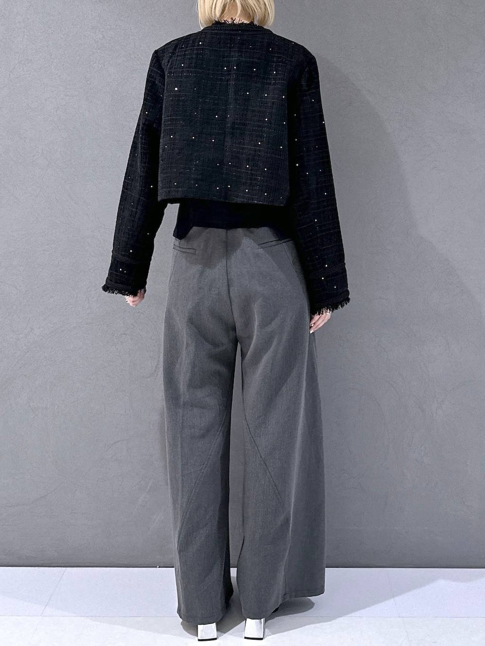 ブラック系のカーディガン/ボレロ、ブラック系のブーツ、グレー系のスラックスを着用したレディースの秋コーディネートの3枚目の写真