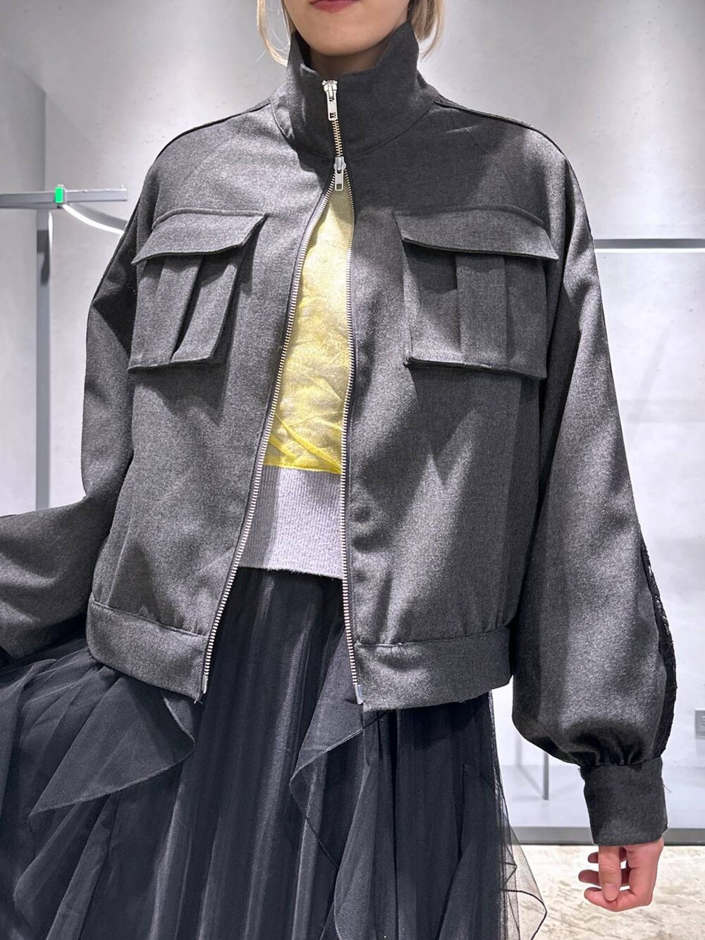 ブラック系のブーツ、イエロー系のカーディガン/ボレロ、グレー系のブルゾンを着用したレディースの冬コーディネートの5枚目の写真