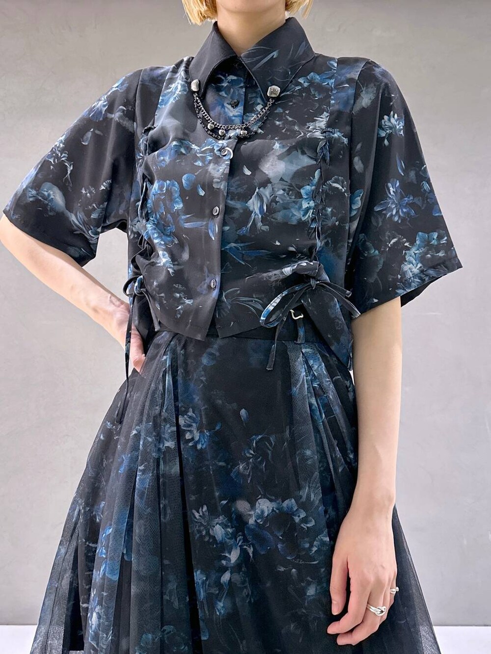 ブラック系のサンダル、ブルー系のシャツ/ブラウス、ブラック系のブローチ/コサージュを着用したレディースの春コーディネートの4枚目の写真