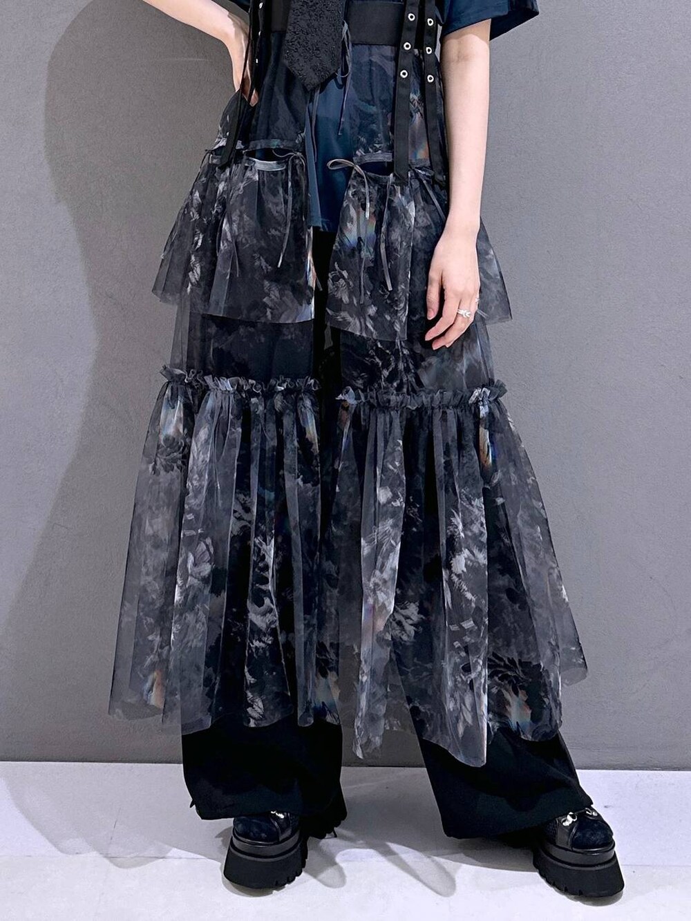 ブラック系のネクタイ、ブラック系のサンダル、グレー系のスカートを着用したレディースの春コーディネートの7枚目の写真