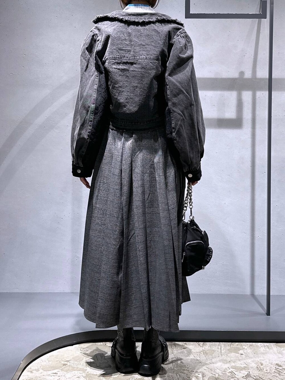 ブラック系のショルダーバッグ、シルバー系のブーツ、グレー系のニット/セーターを着用したレディースの秋コーディネートの3枚目の写真