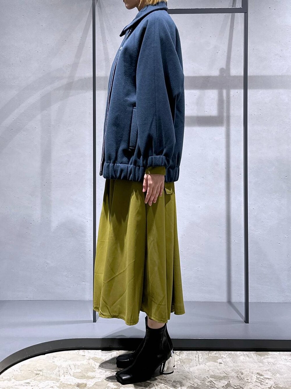 ブラック系のブーツ、ブルー系のブルゾン、イエロー系のワンピースを着用したレディースの冬コーディネートの2枚目の写真