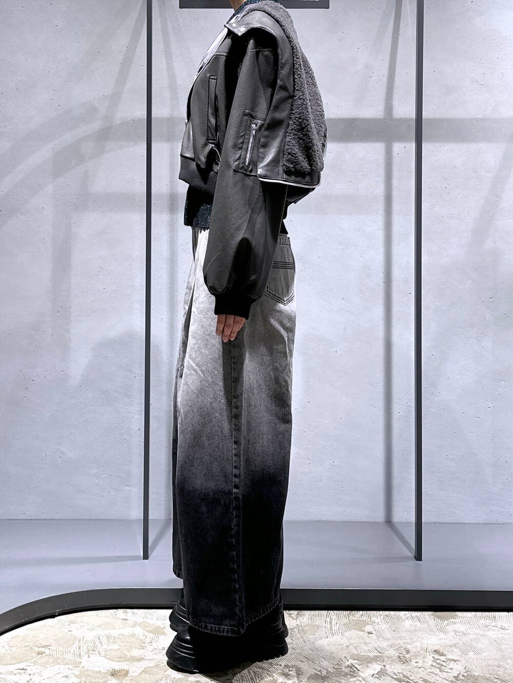 ブラック系のブーツ、グリーン系のカーディガン/ボレロ、グレー系のデニムパンツを着用したレディースの冬コーディネートの2枚目の写真