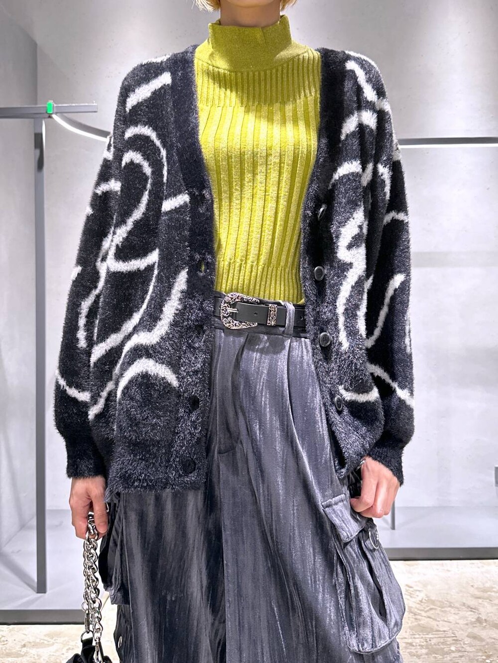 ブラック系のカーディガン/ボレロ、イエロー系のニット/セーター、ブラック系のショルダーバッグを着用したレディースの秋コーディネートの5枚目の写真