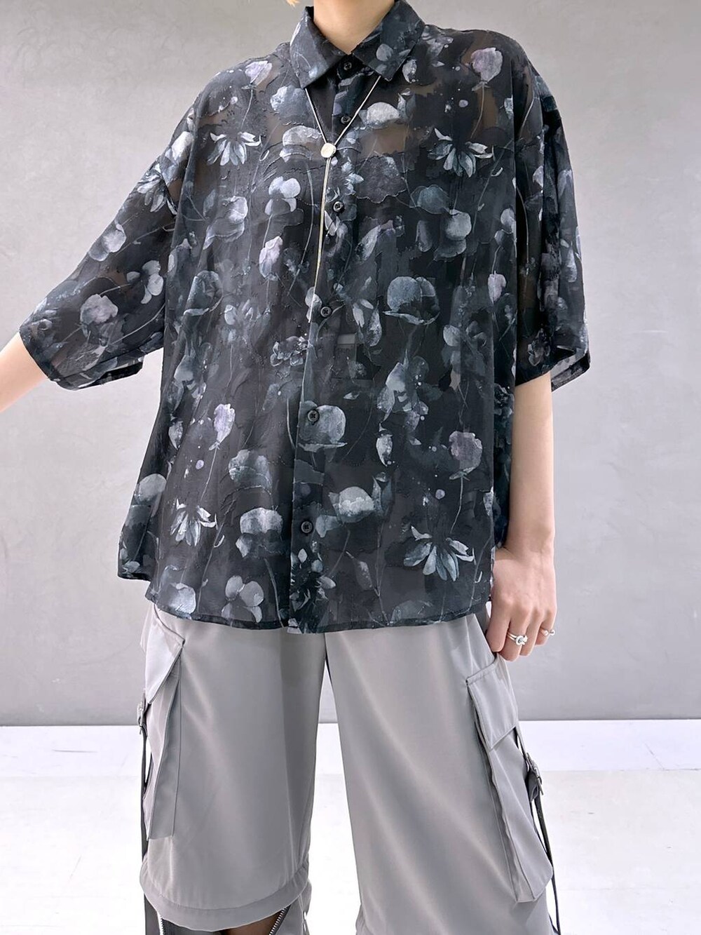 ブラック系のサンダル、グレー系のカーゴパンツ、ブラック系のシャツ/ブラウスを着用したレディースの春コーディネートの5枚目の写真