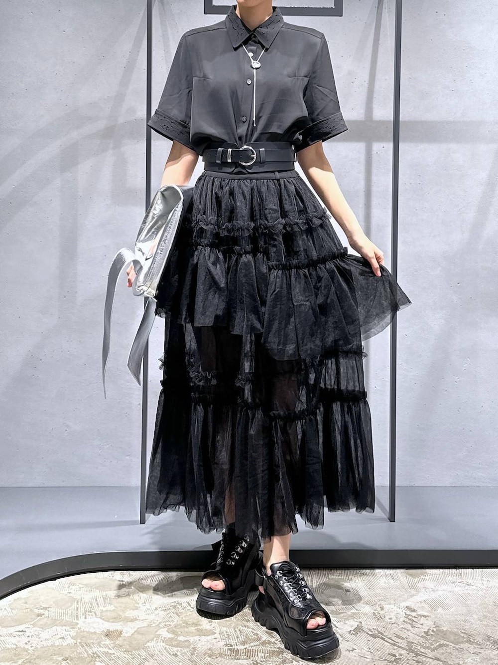 ブラック系のシャツ/ブラウス、ブラック系のサンダル、シルバー系のトートバッグを着用したレディースの夏コーディネートの4枚目の写真