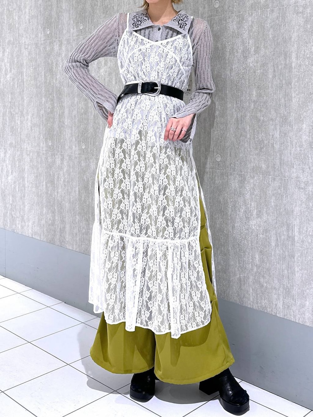 イエロー系のカーゴパンツ、グレー系のニット/セーター、ホワイト系のワンピースを着用したレディースの春コーディネートの4枚目の写真