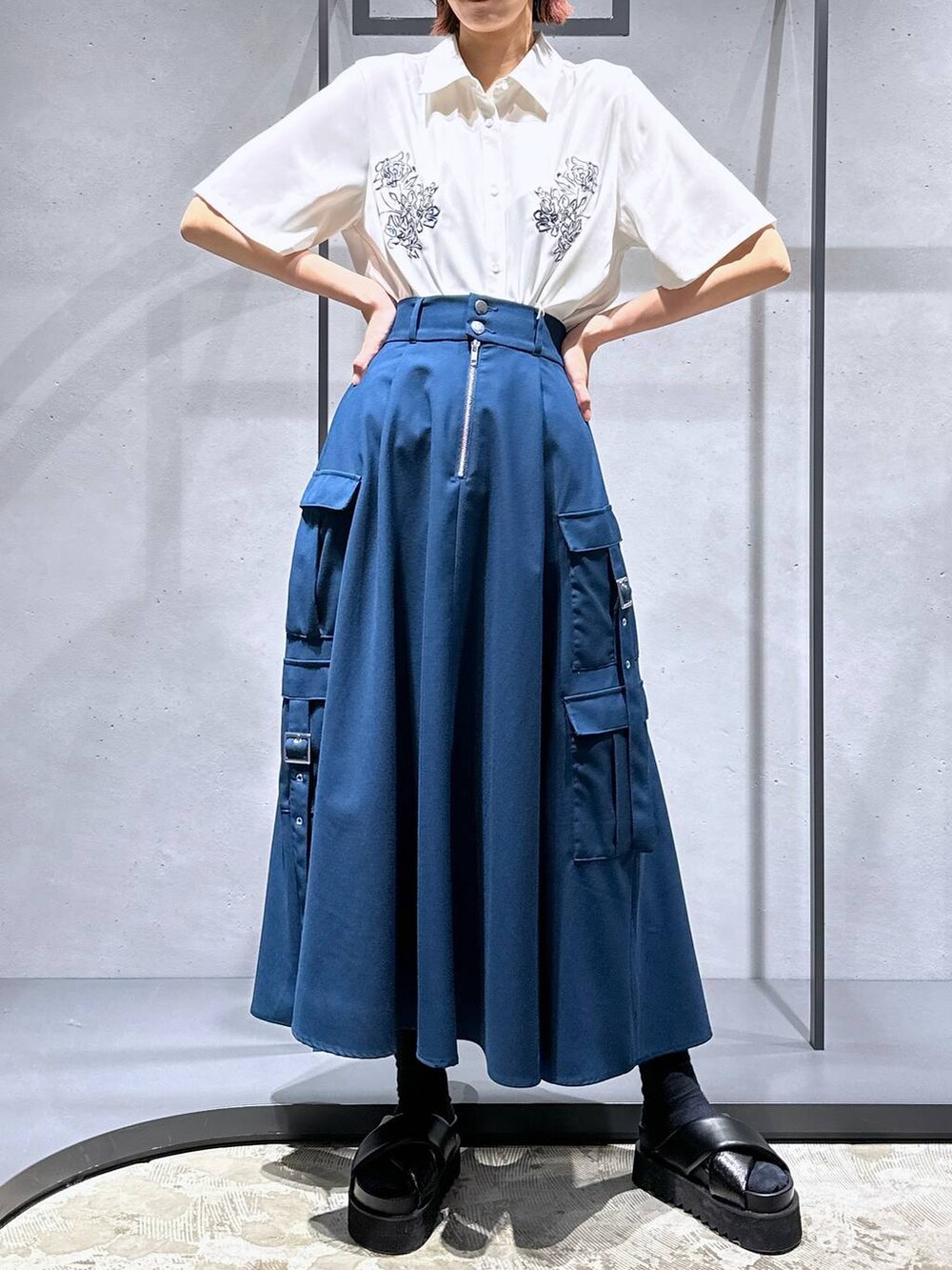 ブラック系のサンダル、ブルー系のスカート、ホワイト系のシャツ/ブラウスを着用したレディースの春コーディネートの5枚目の写真