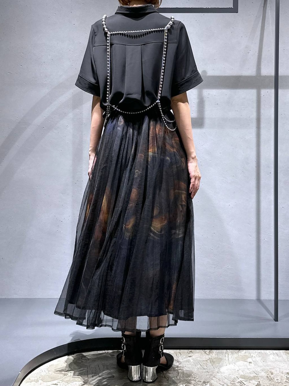 ブラック系のシャツ/ブラウス、ブラック系のサンダル、オレンジ系のスカートを着用したレディースの夏コーディネートの3枚目の写真