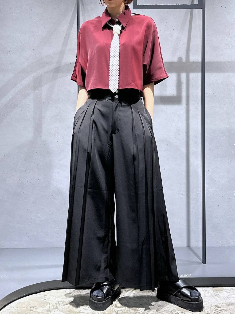 ブラック系のサンダル、ブラック系のその他パンツ、レッド系のシャツ/ブラウスを着用したレディースの夏コーディネートの5枚目の写真