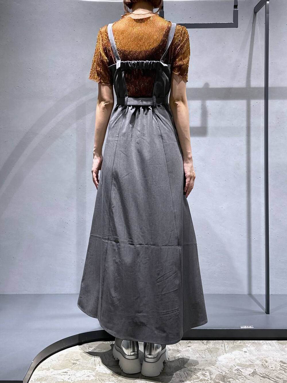 シルバー系のサンダル、オレンジ系のTシャツ/カットソー、グレー系のジャンパースカートを着用したレディースの夏コーディネートの5枚目の写真