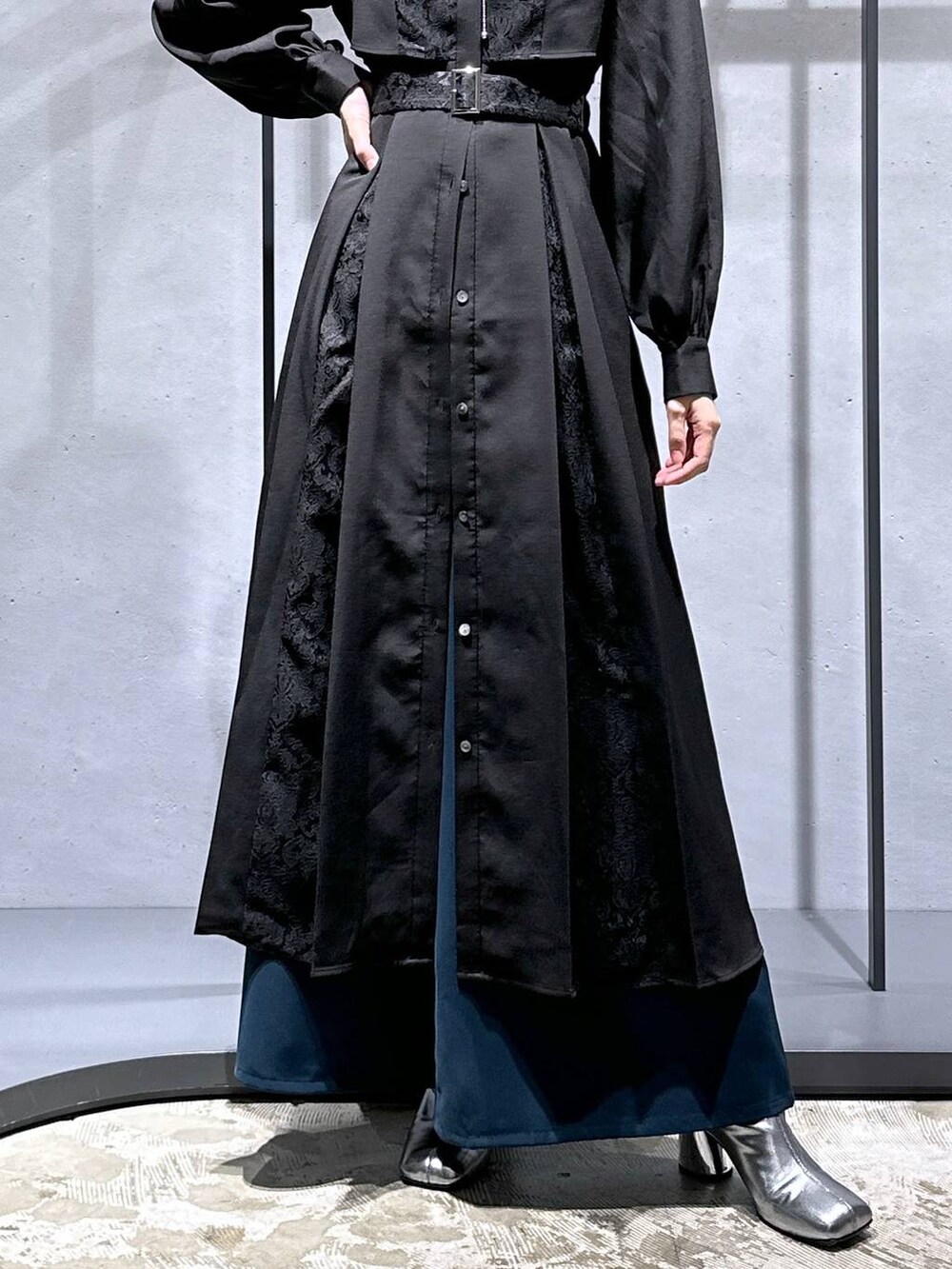 シルバー系のブーツ、ブルー系のその他パンツ、ブラック系のワンピースを着用したレディースの秋コーディネートの6枚目の写真