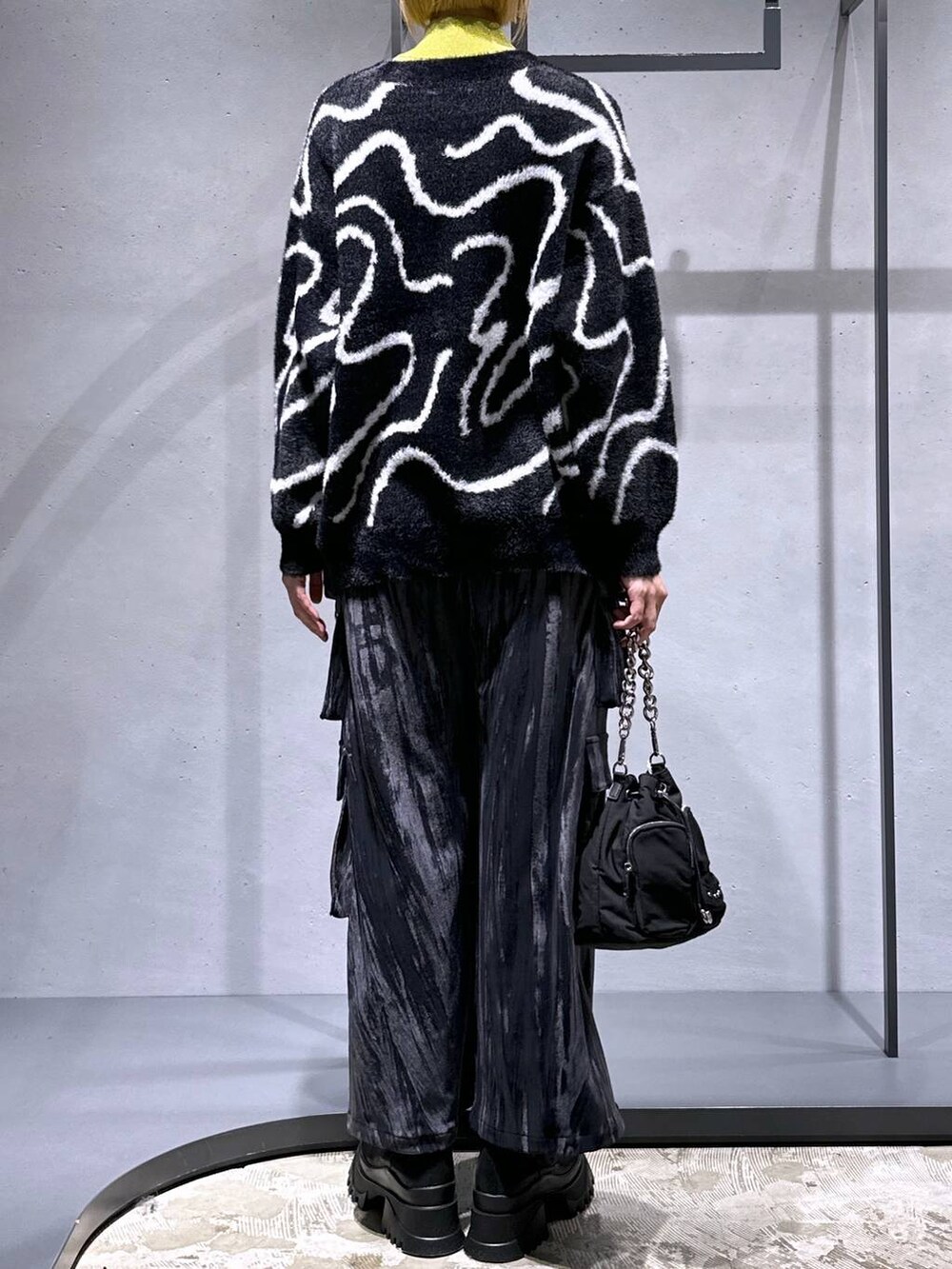 ブラック系のカーディガン/ボレロ、イエロー系のニット/セーター、ブラック系のショルダーバッグを着用したレディースの秋コーディネートの3枚目の写真