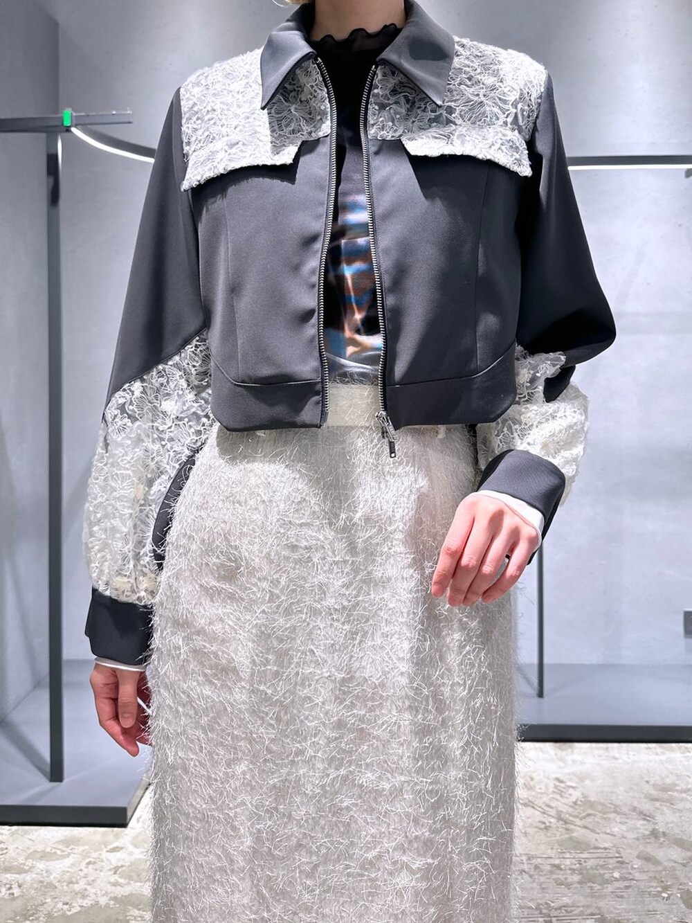 ブラック系のTシャツ/カットソー、ブラック系のスニーカー、ホワイト系のスカートを着用したレディースの冬コーディネートの5枚目の写真