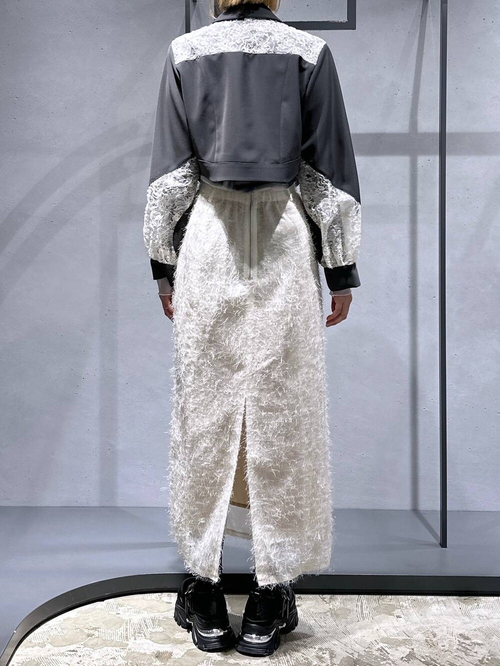 ブラック系のTシャツ/カットソー、ブラック系のスニーカー、ホワイト系のスカートを着用したレディースの冬コーディネートの3枚目の写真