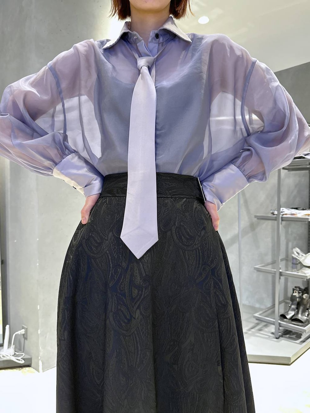 ブラック系のサンダル、ブラック系のスカート、パープル系のシャツ/ブラウスを着用したレディースの春コーディネートの2枚目の写真