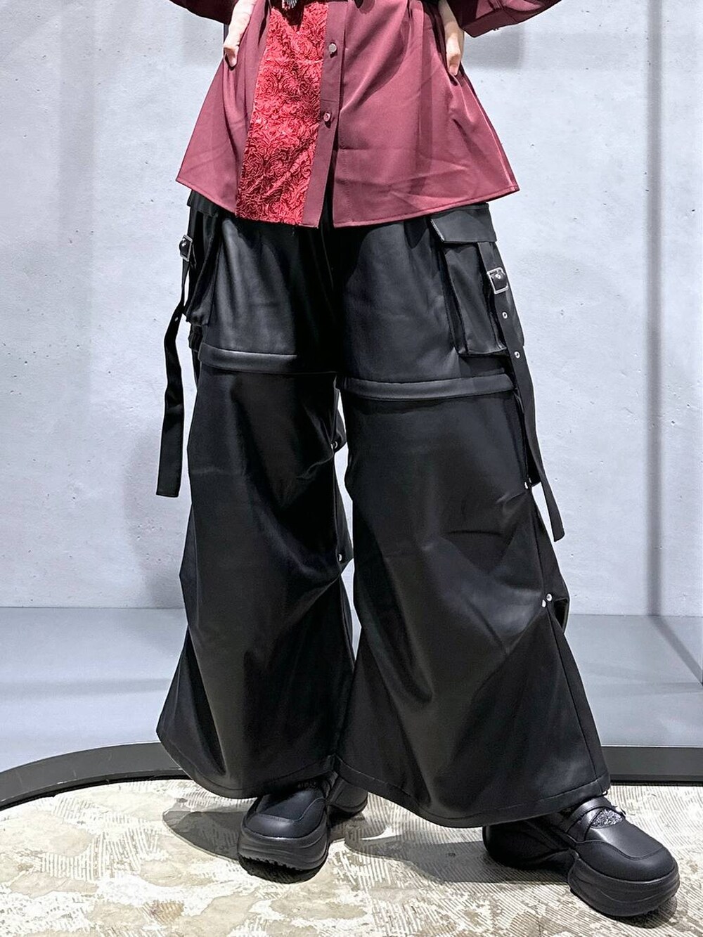 ブラック系のカーゴパンツ、ブラック系のブーツ、レッド系のシャツ/ブラウスを着用したレディースの夏コーディネートの6枚目の写真