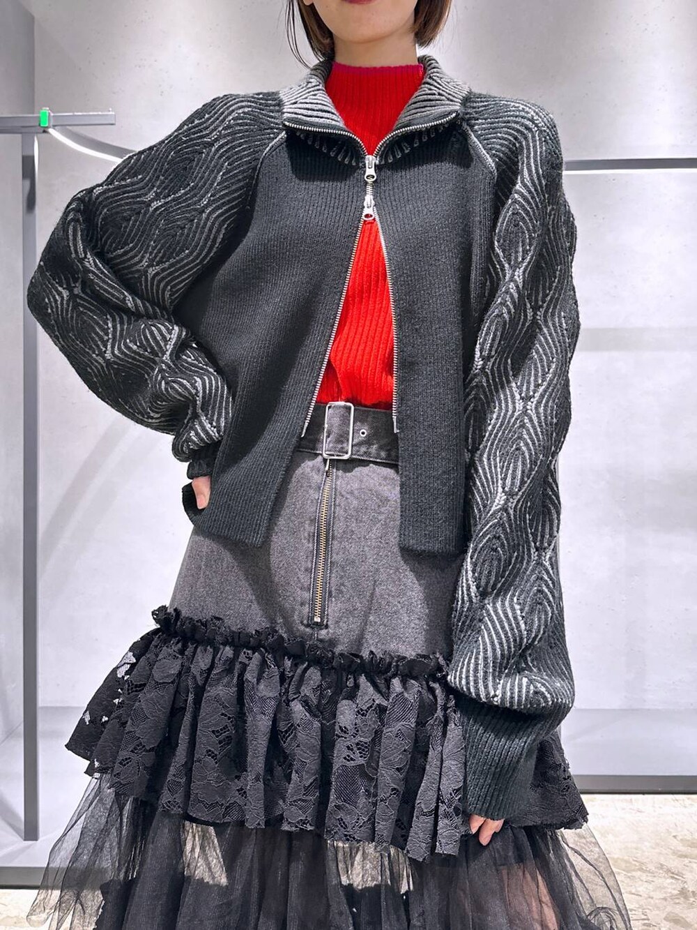 ブラック系のブーツ、ブラック系のカーディガン/ボレロ、レッド系のニット/セーターを着用したレディースの秋コーディネートの5枚目の写真