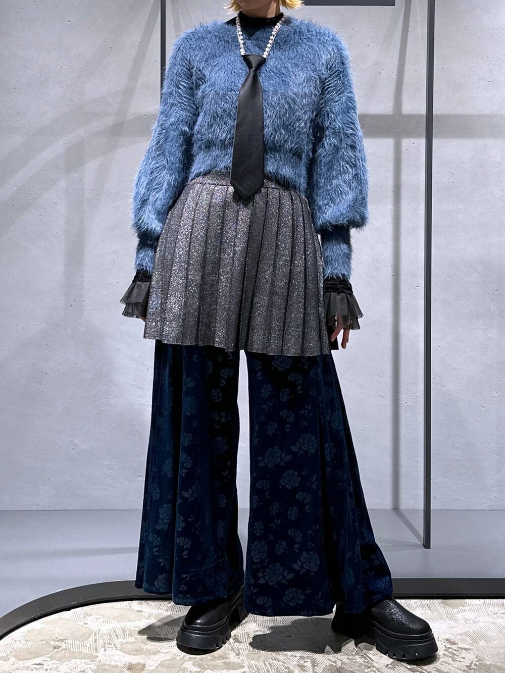 ブラック系のネクタイ、ブルー系のニット/セーター、ブラック系のTシャツ/カットソーを着用したレディースの冬コーディネートの4枚目の写真