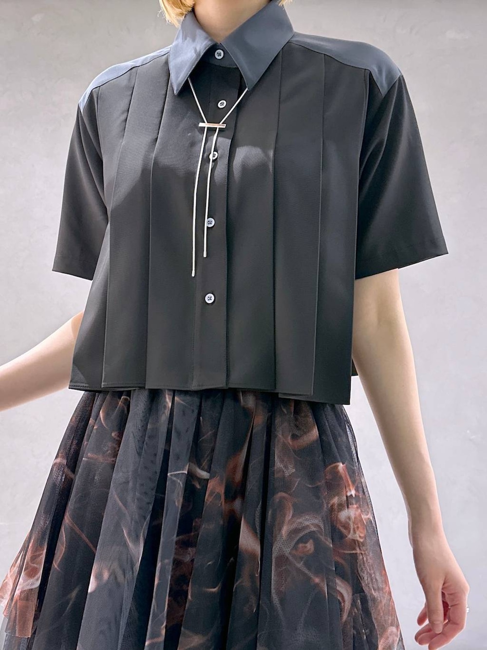 ブラック系のサンダル、オレンジ系のスカート、ブラック系のシャツ/ブラウスを着用したレディースの夏コーディネートの5枚目の写真