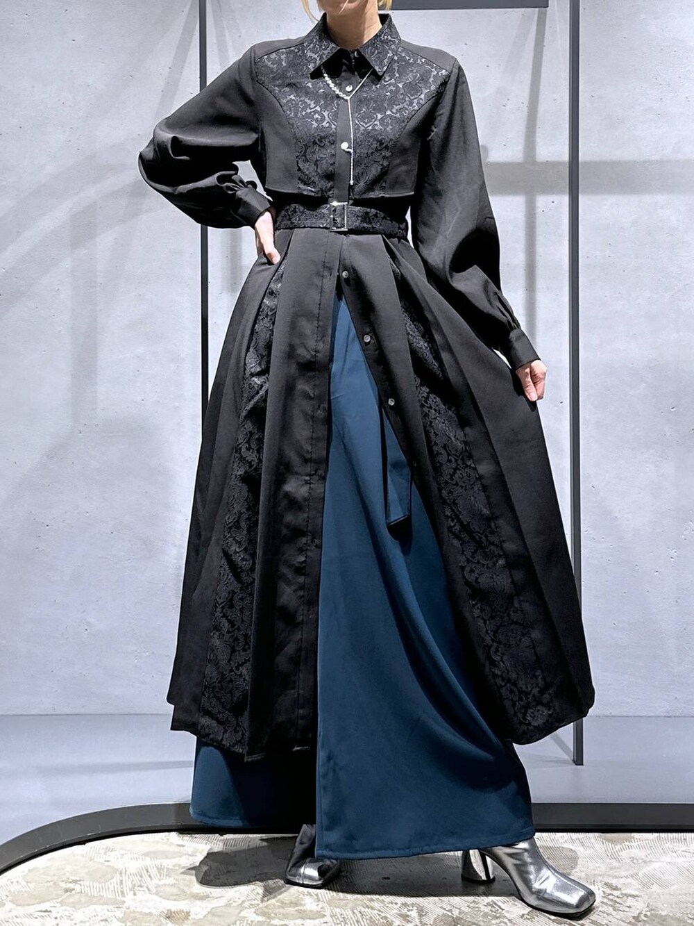 シルバー系のブーツ、ブルー系のその他パンツ、ブラック系のワンピースを着用したレディースの秋コーディネートの4枚目の写真