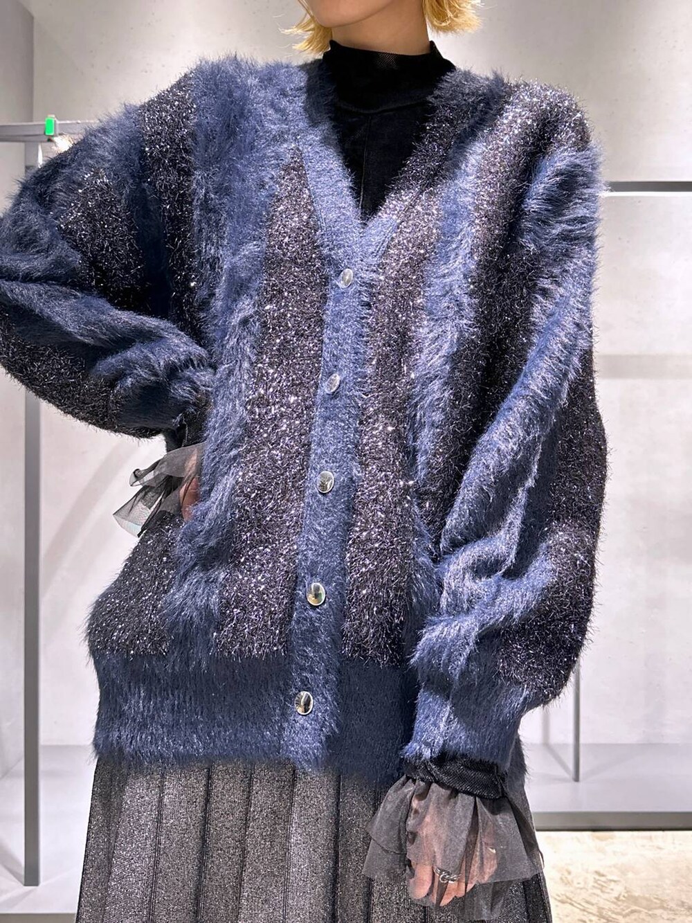 ブラック系のTシャツ/カットソー、ブラック系のブーツ、ブラック系のスカートを着用したレディースの冬コーディネートの5枚目の写真