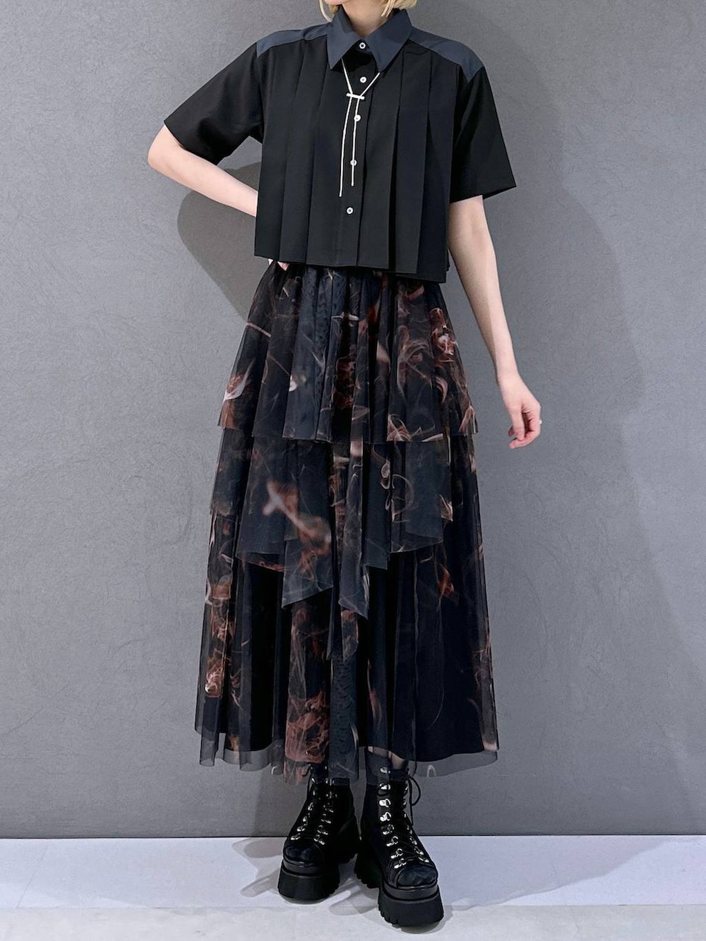 ブラック系のサンダル、オレンジ系のスカート、ブラック系のシャツ/ブラウスを着用したレディースの夏コーディネートの4枚目の写真