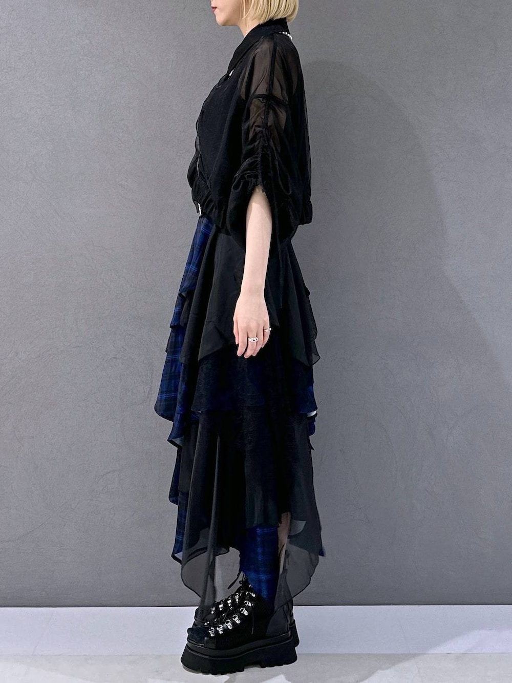 ブラック系のサンダル、ブルー系のスカート、ブラック系のブルゾンを着用したレディースの夏コーディネートの2枚目の写真