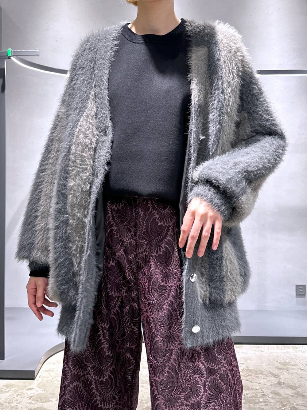 グレー系のカーディガン/ボレロ、シルバー系のブーツ、ブラック系のニット/セーターを着用したレディースの秋コーディネートの5枚目の写真