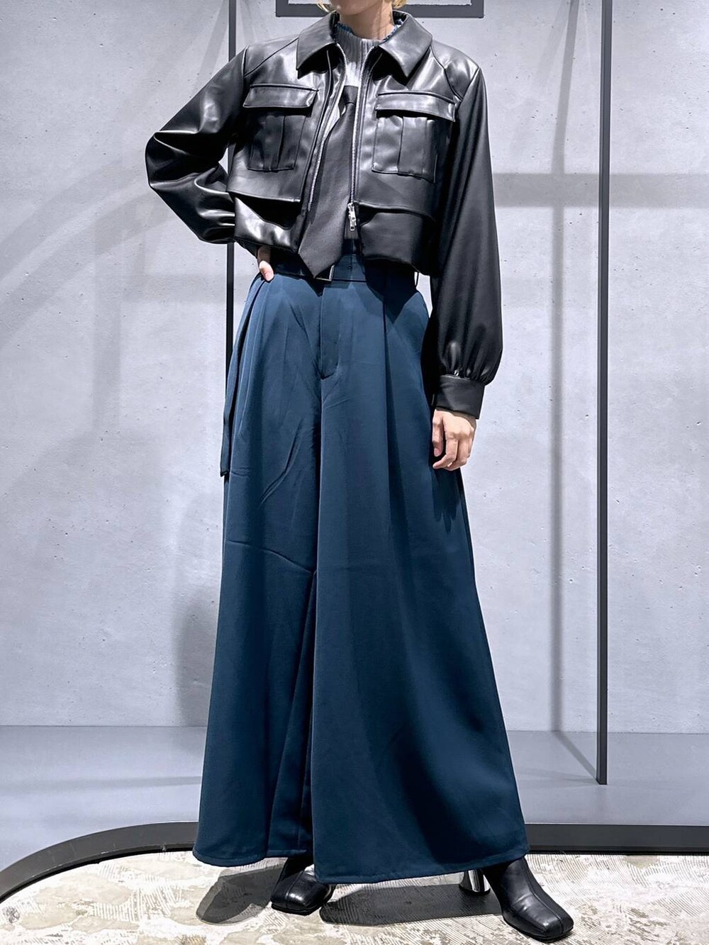 ブラック系のネクタイ、ブラック系のブーツ、グレー系のニット/セーターを着用したレディースの秋コーディネートの4枚目の写真