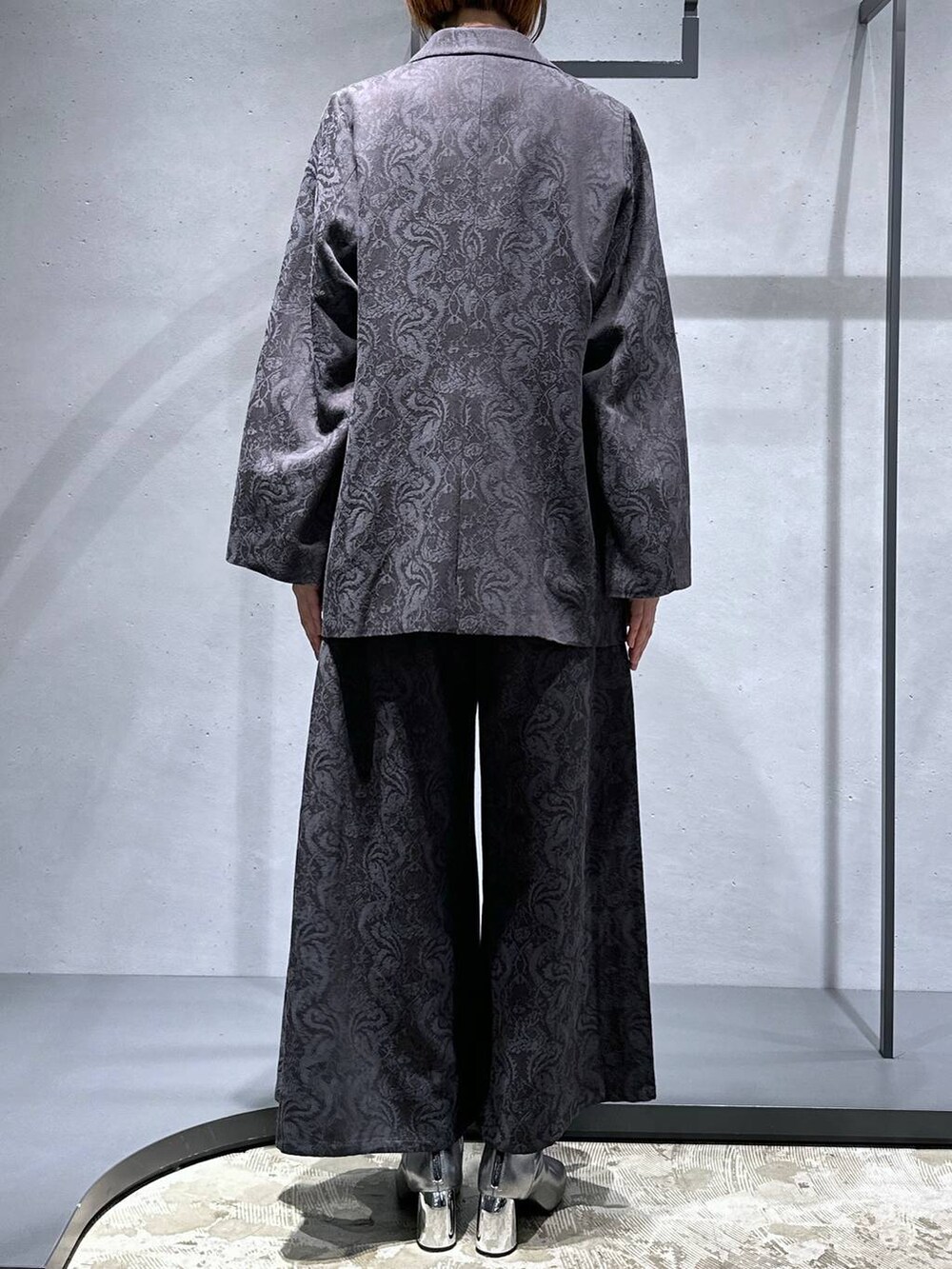 シルバー系のブーツ、グレー系のその他パンツ、グレー系のテーラードジャケットを着用したレディースの秋コーディネートの3枚目の写真