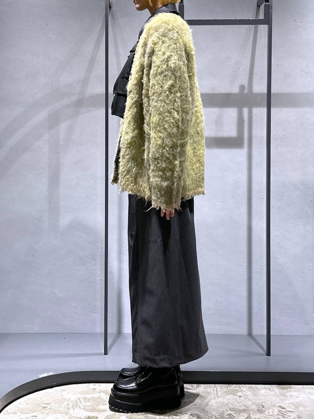 ブラック系のブルゾン、ブラック系のドレスシューズ、イエロー系のカーディガン/ボレロを着用したレディースの秋コーディネートの2枚目の写真