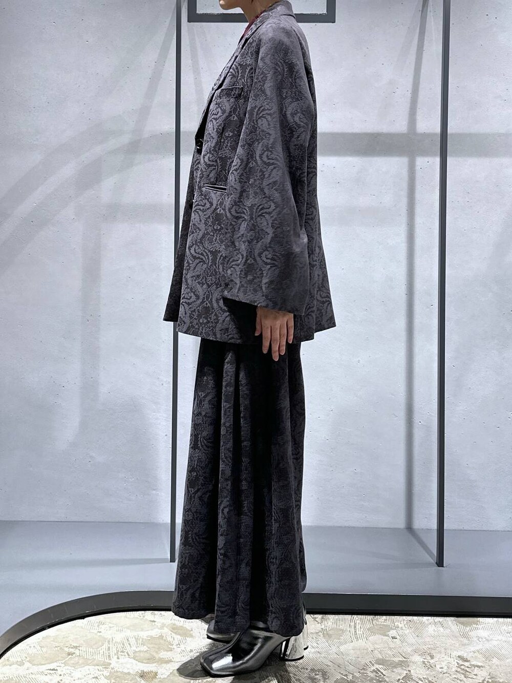 シルバー系のブーツ、グレー系のその他パンツ、グレー系のテーラードジャケットを着用したレディースの秋コーディネートの2枚目の写真