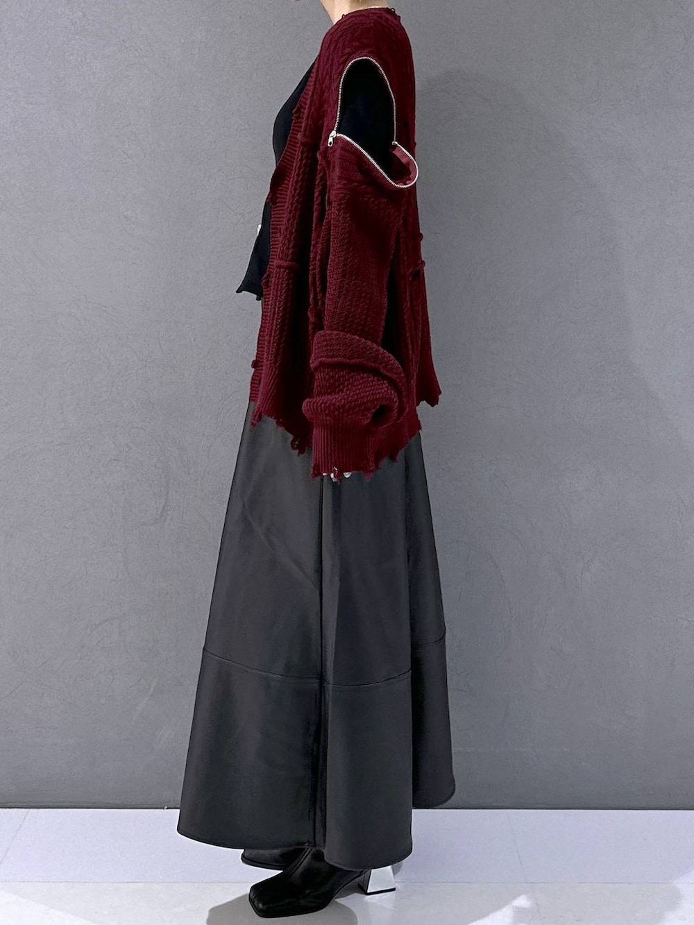 ブラック系のカーディガン/ボレロ、ブラック系のブーツ、レッド系のカーディガン/ボレロを着用したレディースの秋コーディネートの2枚目の写真