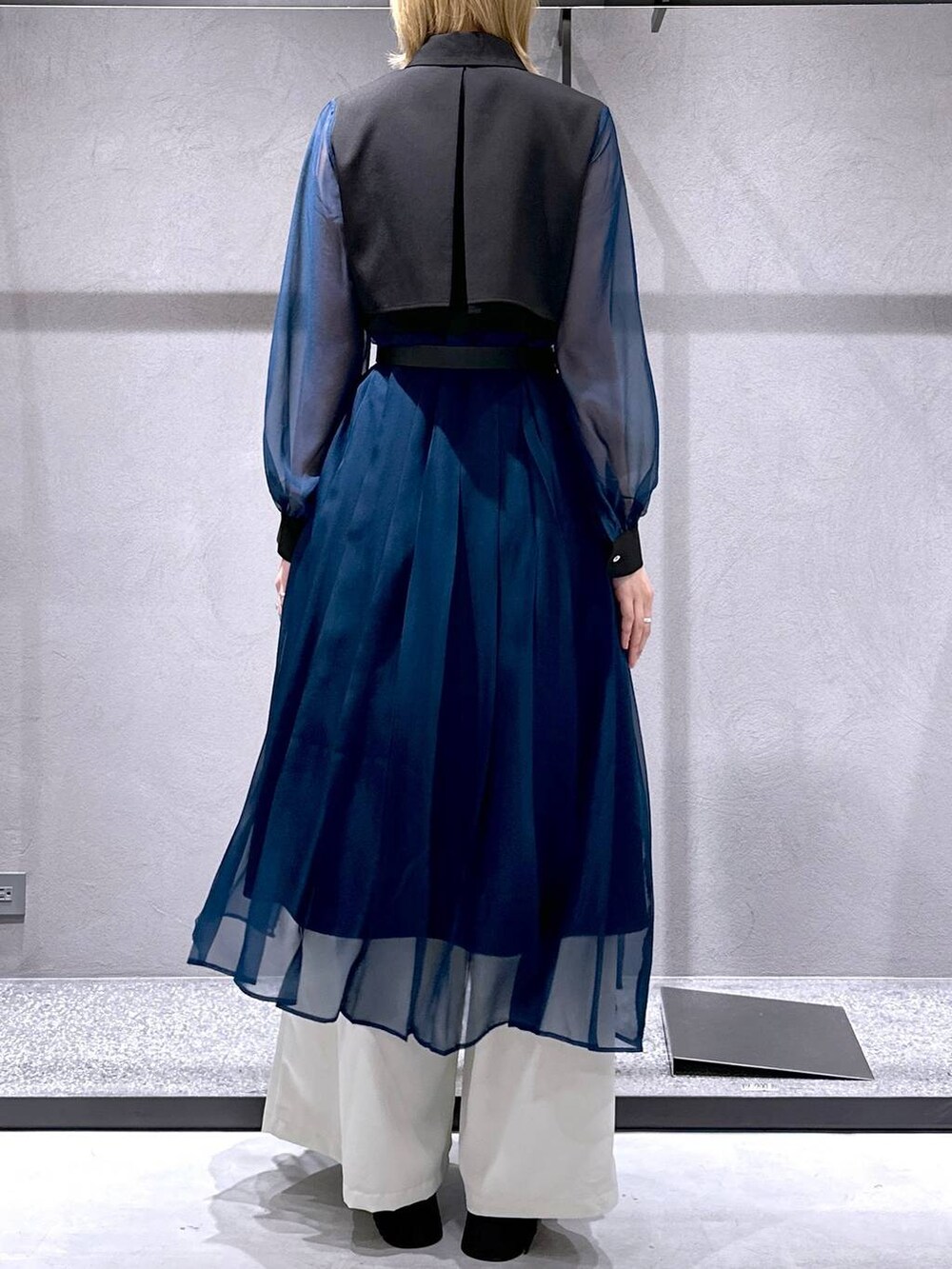 シルバー系のサンダル、ブラック系のワンピース、ホワイト系のスラックスを着用したレディースの春コーディネートの3枚目の写真