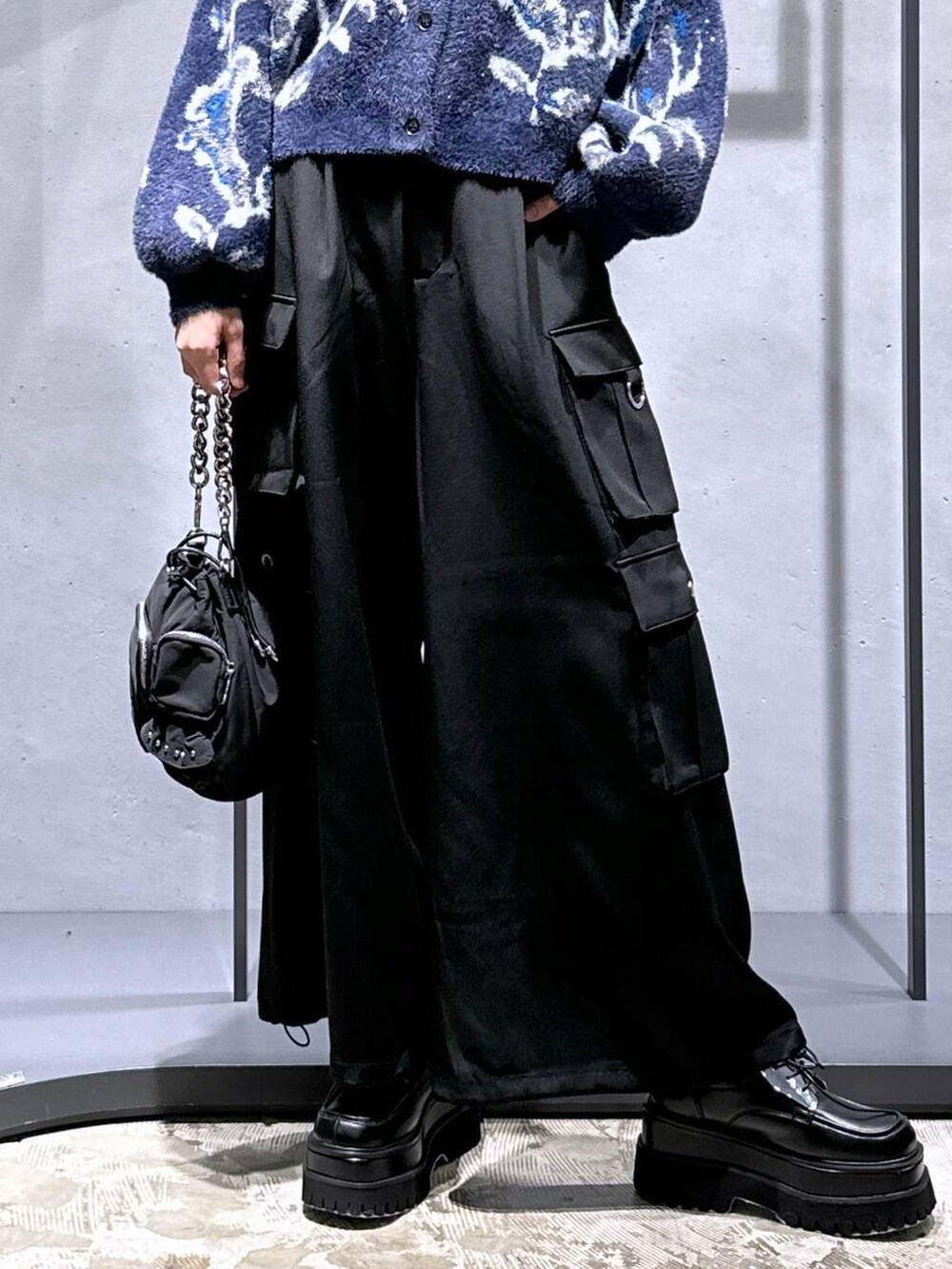 パープル系のカーディガン/ボレロ、ブラック系のショルダーバッグ、ブラック系のカーゴパンツを着用したレディースの秋コーディネートの6枚目の写真