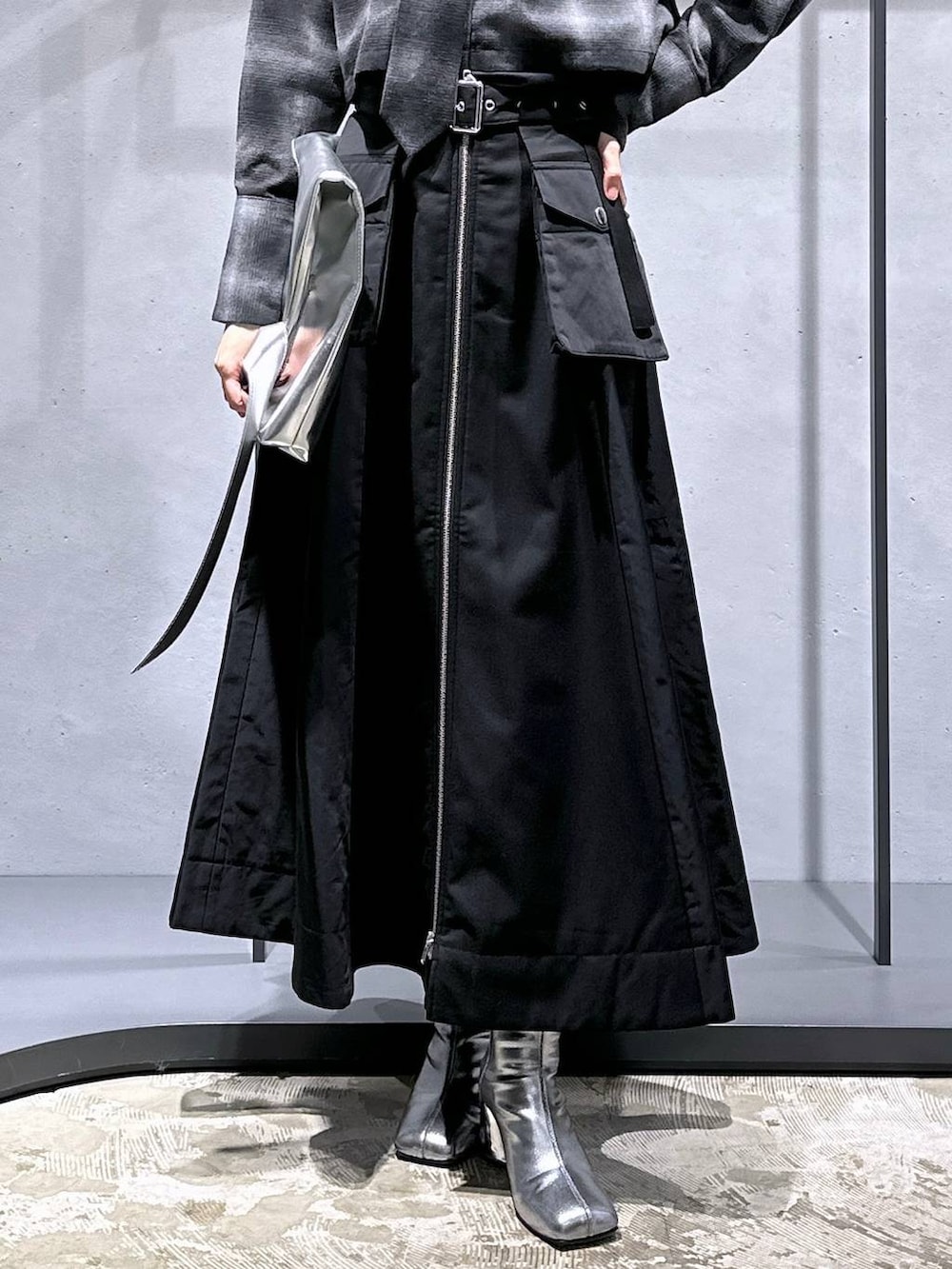 シルバー系のブーツ、ブラック系のスカート、シルバー系のトートバッグを着用したレディースの秋コーディネートの6枚目の写真