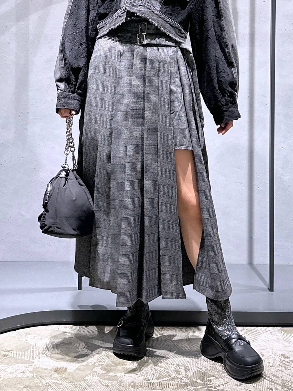 ブラック系のショルダーバッグ、シルバー系のブーツ、グレー系のニット/セーターを着用したレディースの秋コーディネートの6枚目の写真