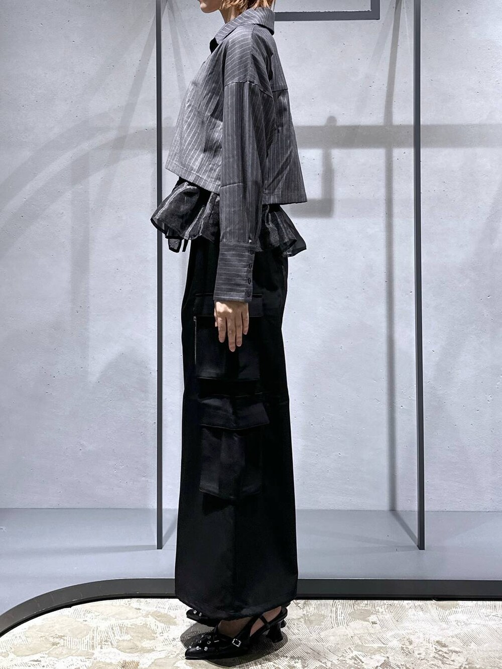 ブラック系のパンプス、ブラック系のベスト、ブラック系のカーゴパンツを着用したレディースの夏コーディネートの2枚目の写真