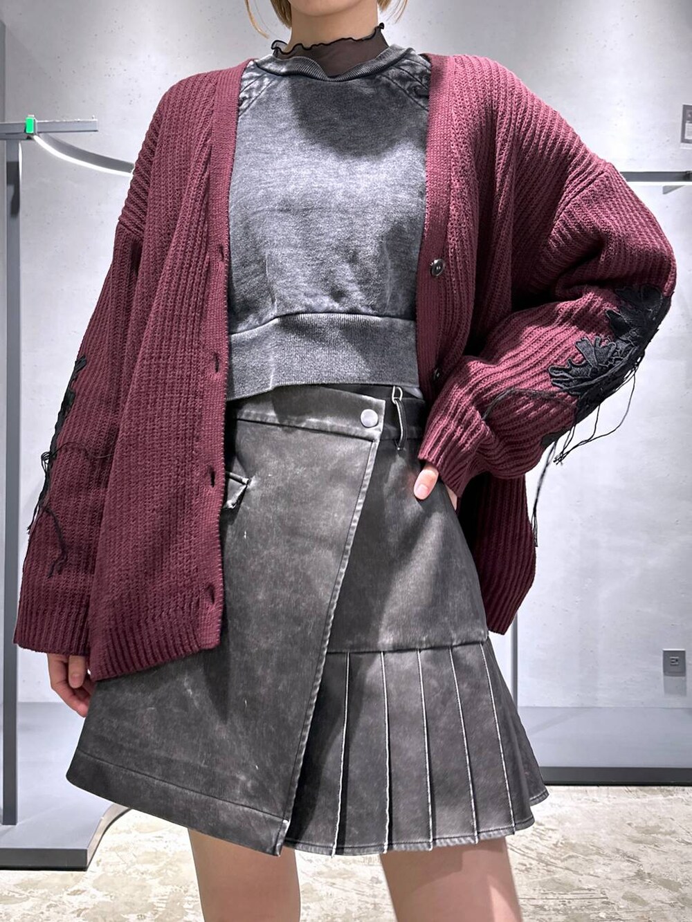 レッド系のカーディガン/ボレロ、ブラック系のスウェット、ブラック系のスニーカーを着用したレディースの冬コーディネートの5枚目の写真