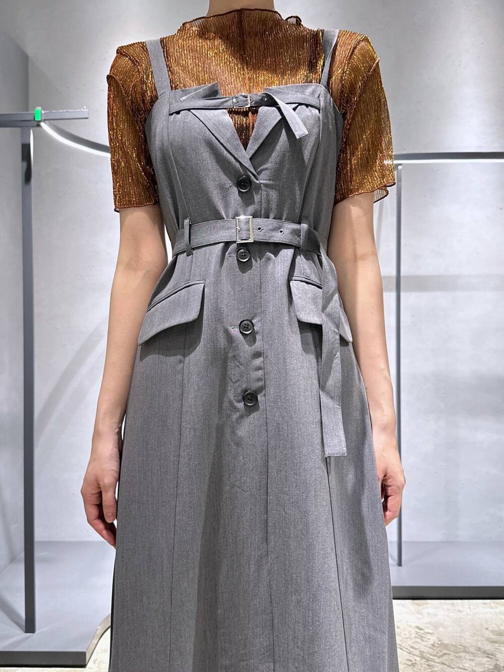 シルバー系のサンダル、オレンジ系のTシャツ/カットソー、グレー系のジャンパースカートを着用したレディースの夏コーディネートの2枚目の写真