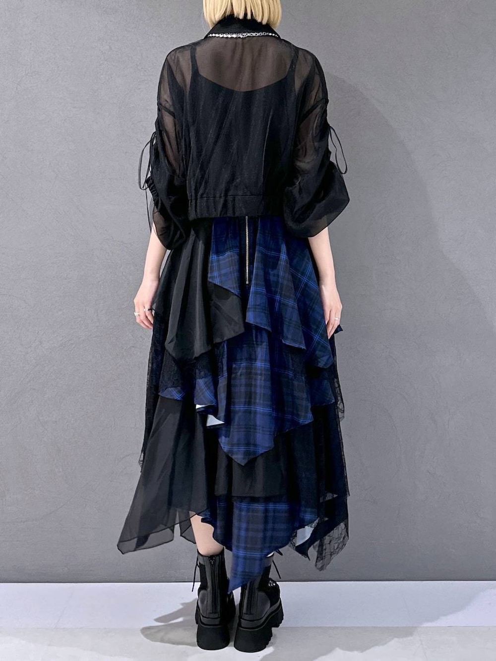 ブラック系のサンダル、ブルー系のスカート、ブラック系のブルゾンを着用したレディースの夏コーディネートの3枚目の写真