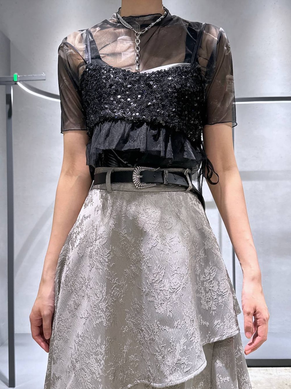 ブラック系のサンダル、ブラック系のチューブトップ、グレー系のスカートを着用したレディースの夏コーディネートの2枚目の写真