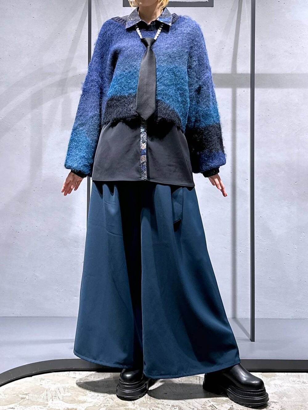 ブラック系のネクタイ、ブルー系のその他パンツ、ブラック系のブーツを着用したレディースの冬コーディネートの4枚目の写真