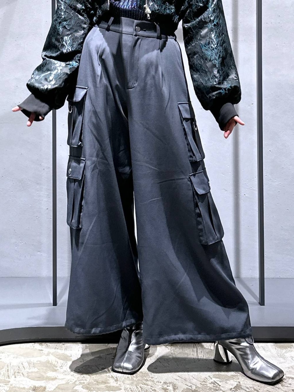 グリーン系のブルゾン、シルバー系のブーツ、ブルー系のニット/セーターを着用したレディースの秋コーディネートの6枚目の写真