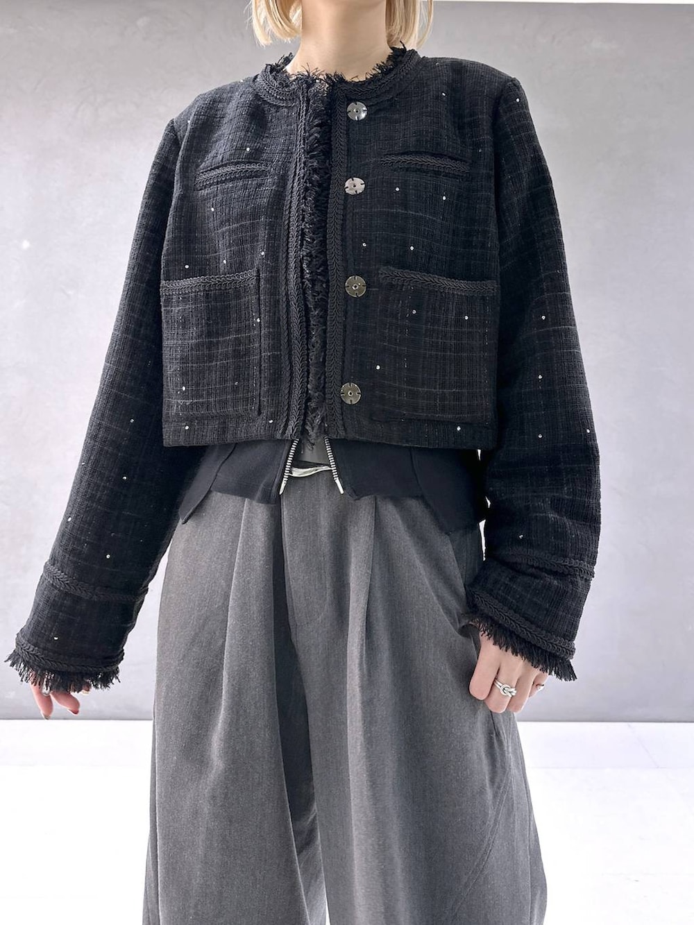 ブラック系のカーディガン/ボレロ、ブラック系のブーツ、グレー系のスラックスを着用したレディースの秋コーディネートの6枚目の写真